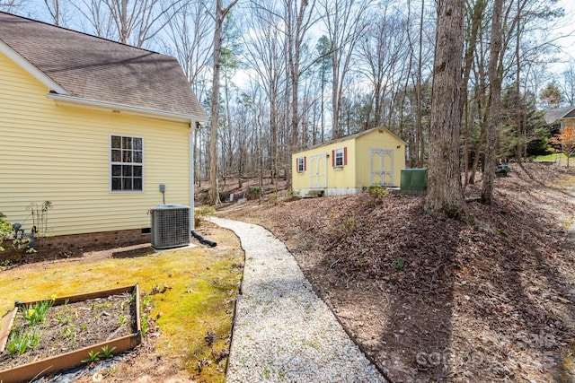 view of yard with an outbuilding, a garden, and central AC