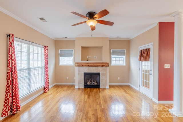 unfurnished living room featuring light wood-type flooring, baseboards, crown molding, and a tile fireplace