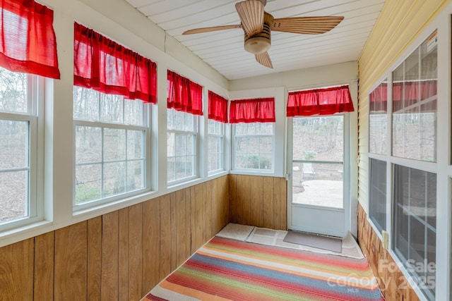 unfurnished sunroom featuring a ceiling fan and a healthy amount of sunlight