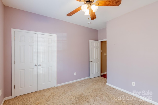 unfurnished bedroom with a closet, carpet flooring, a ceiling fan, and baseboards