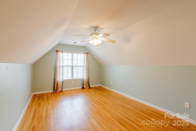 bonus room featuring light wood-type flooring, ceiling fan, baseboards, and vaulted ceiling