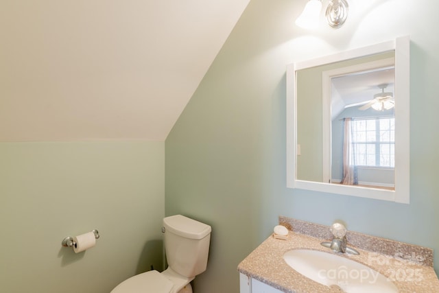 bathroom featuring toilet, lofted ceiling, and vanity