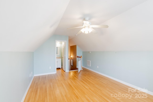 additional living space featuring light wood-type flooring, baseboards, visible vents, and a ceiling fan