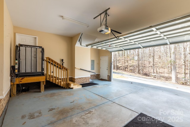 garage with a garage door opener and electric panel