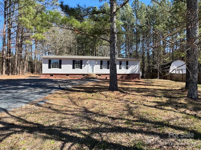 view of front of house with entry steps, crawl space, and driveway