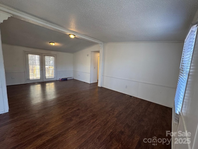 spare room with lofted ceiling, french doors, dark wood-type flooring, and a textured ceiling