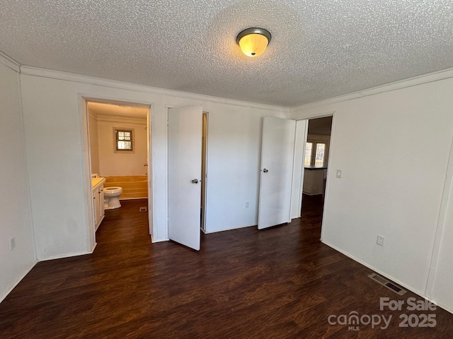 unfurnished bedroom with wood finished floors, visible vents, and crown molding