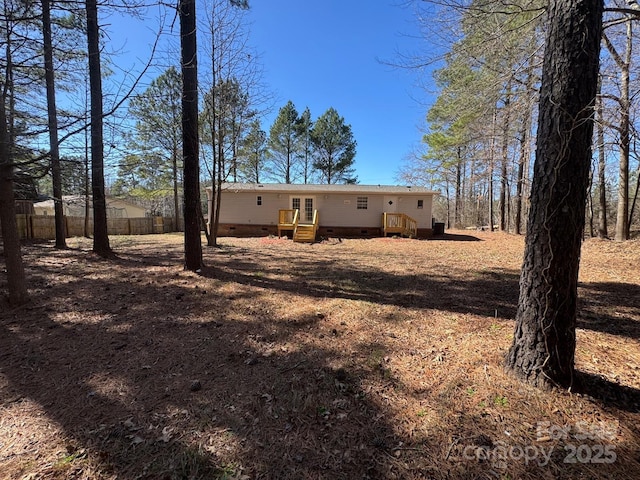 back of property featuring crawl space and fence