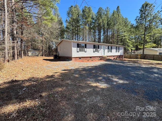 manufactured / mobile home featuring entry steps, crawl space, fence, and driveway