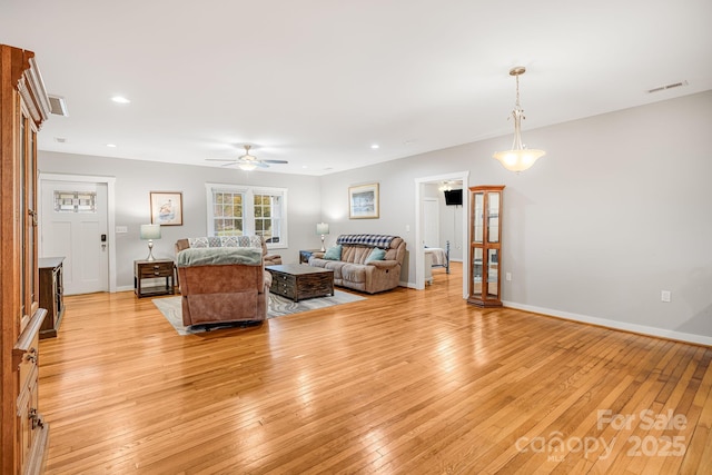 living room with light wood-style floors, recessed lighting, visible vents, and baseboards