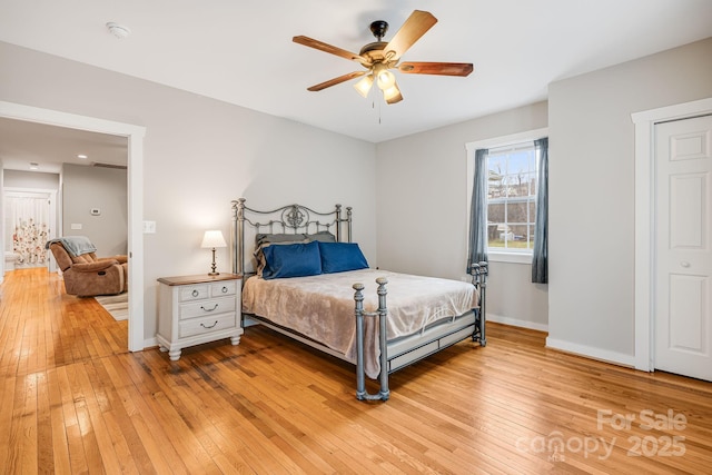 bedroom featuring a ceiling fan, light wood-style flooring, and baseboards