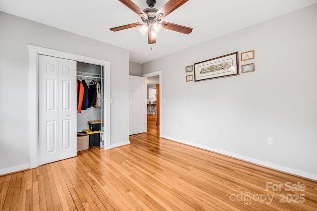 unfurnished bedroom with a closet, baseboards, ceiling fan, and light wood finished floors