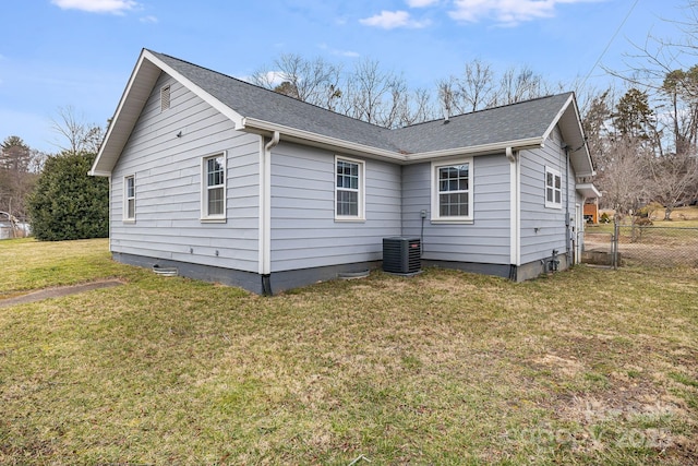 back of house featuring roof with shingles, a yard, a gate, central AC, and fence