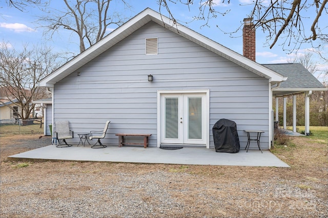 rear view of property featuring french doors, a patio area, and a chimney