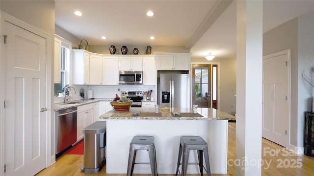 50 Rose Creek Rd, Leicester, NC 28748 - kitchen featuring a breakfast bar, white cabinetry, tasteful backsplash, a sink, and appliances with stainless steel finishes