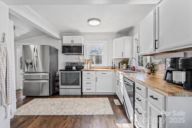 kitchen featuring stainless steel appliances, dark wood-type flooring, wooden counters, and white cabinetry