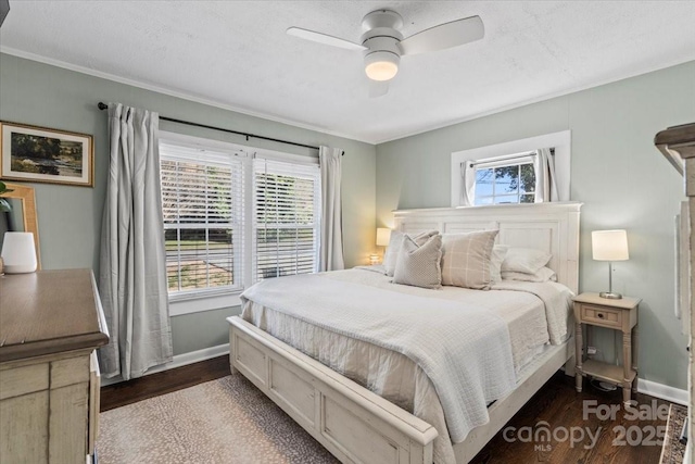 bedroom featuring dark wood-style floors, ceiling fan, crown molding, and baseboards