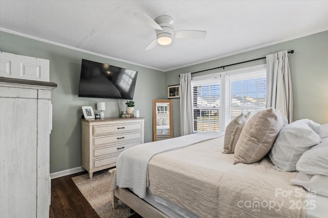 bedroom featuring dark wood-style floors, baseboards, ornamental molding, and ceiling fan