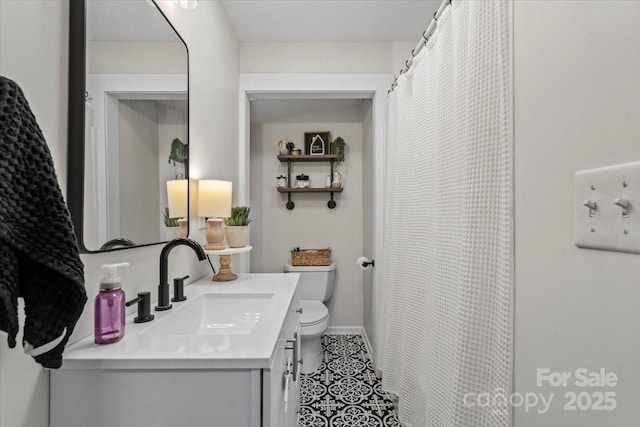 full bath with baseboards, vanity, and toilet