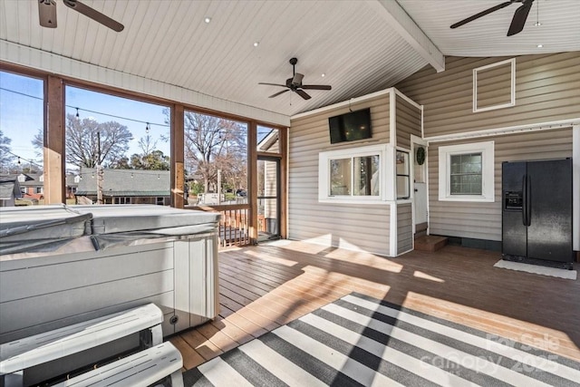 wooden terrace featuring ceiling fan and a hot tub