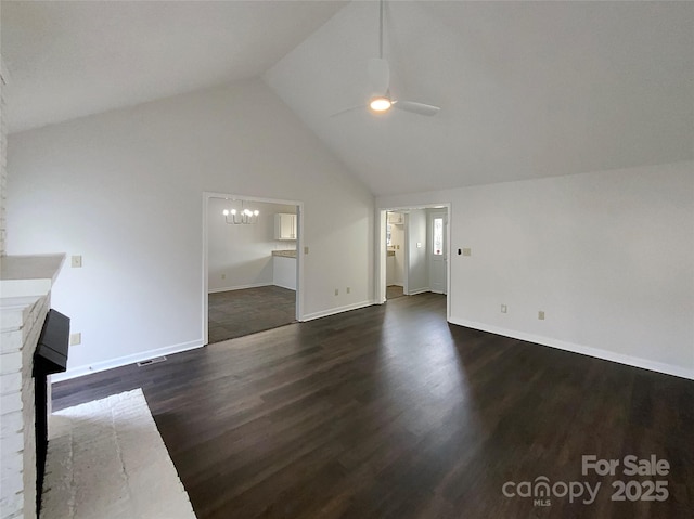 unfurnished living room with high vaulted ceiling, dark wood-style flooring, baseboards, and ceiling fan with notable chandelier