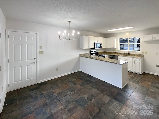 kitchen with a peninsula, appliances with stainless steel finishes, a sink, and white cabinetry