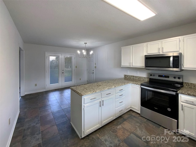 kitchen with baseboards, white cabinets, light stone counters, a peninsula, and stainless steel appliances