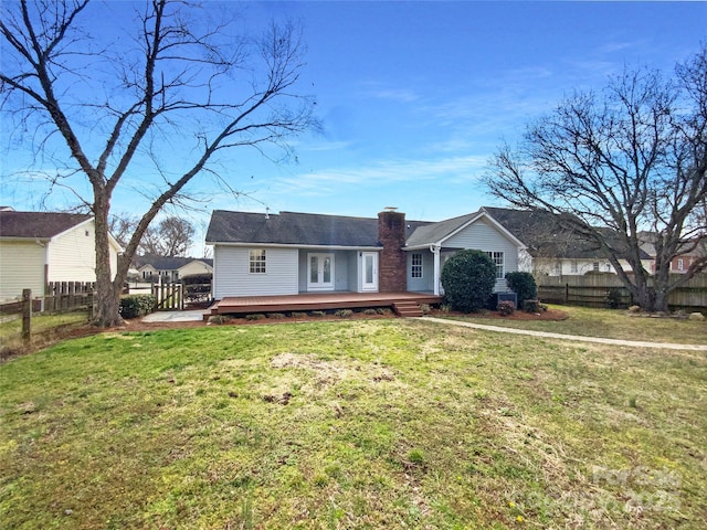 ranch-style home featuring a chimney, a front yard, a fenced backyard, and a wooden deck