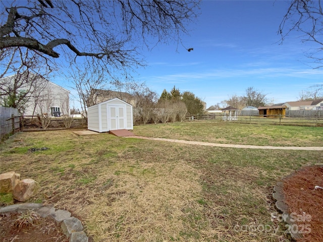 view of yard with a fenced backyard, an outdoor structure, and a storage shed