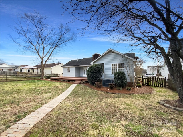 view of front of property with central AC unit, a fenced backyard, a wooden deck, a front lawn, and a chimney