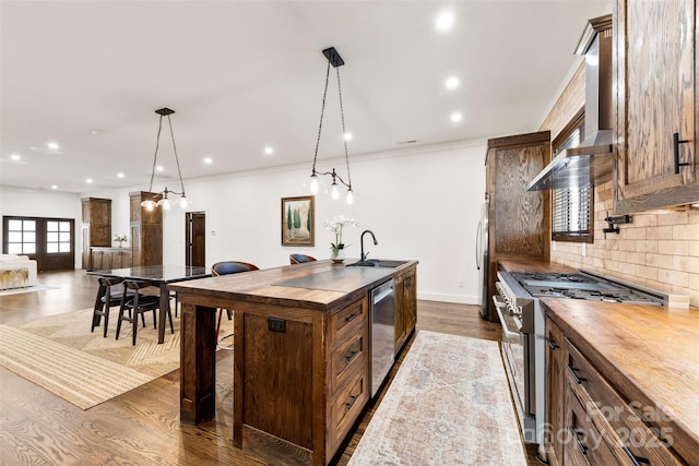 13124 Lemmond Dr, Matthews, NC 28105 - kitchen with wood counters, stainless steel appliances, backsplash, an island with sink, and hanging light fixtures