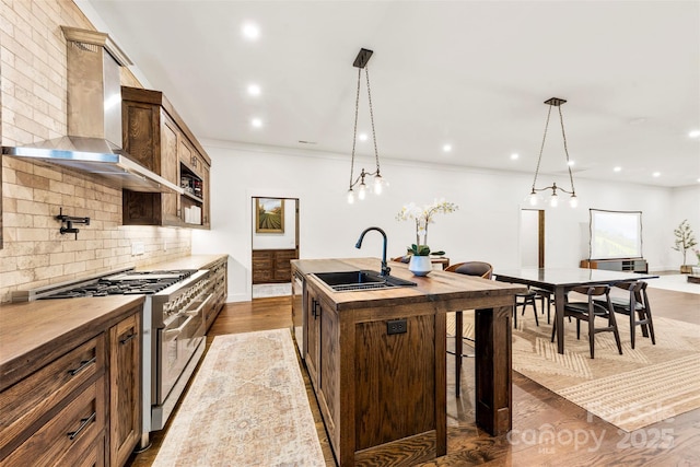 13124 Lemmond Dr, Matthews, NC 28105 - kitchen featuring stainless steel appliances, wall chimney exhaust hood, butcher block counters, a center island with sink, and backsplash