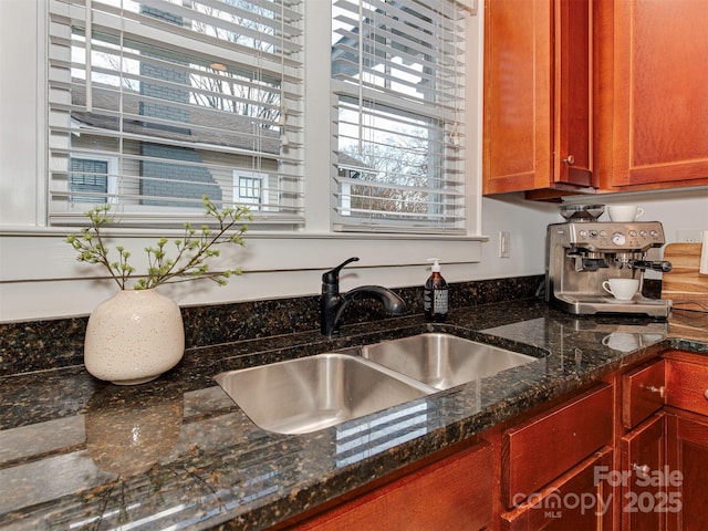 kitchen featuring dark stone counters and a sink