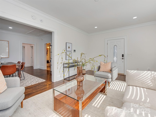 living area with attic access, recessed lighting, ornamental molding, and wood finished floors