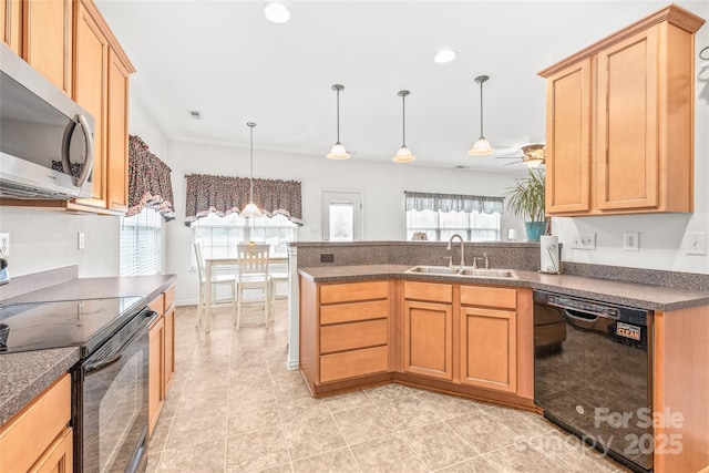 kitchen with dark countertops, recessed lighting, a sink, a peninsula, and black appliances