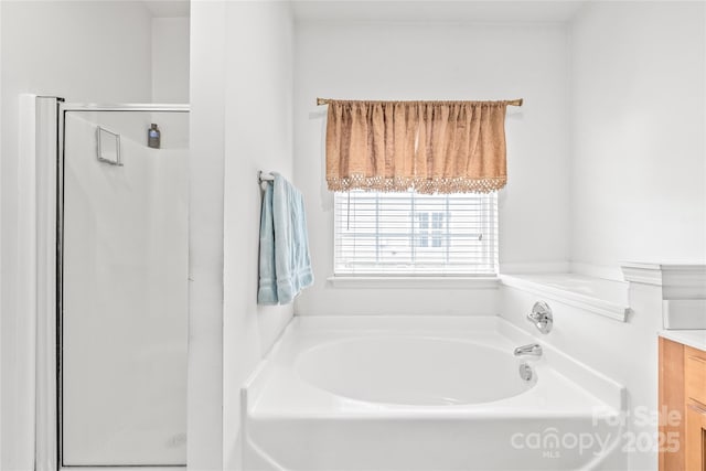 full bath with a garden tub, a shower stall, and vanity