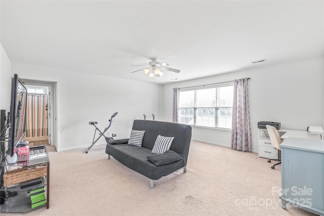 sitting room with a ceiling fan, visible vents, light carpet, and baseboards