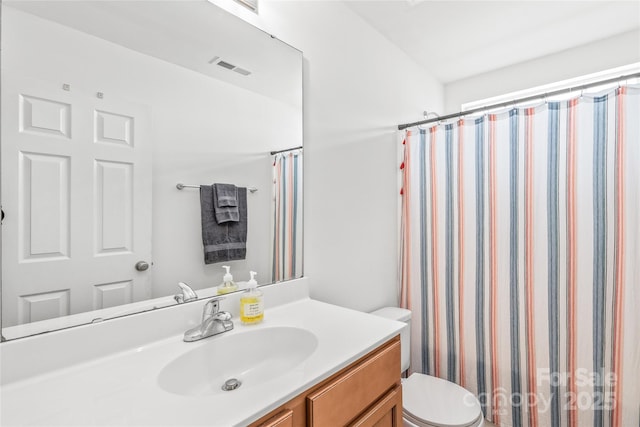 bathroom with visible vents, curtained shower, vanity, and toilet