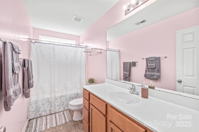 bathroom featuring visible vents, vanity, toilet, and tile patterned floors