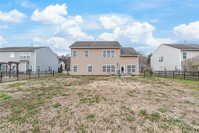 back of house with a fenced backyard and a lawn