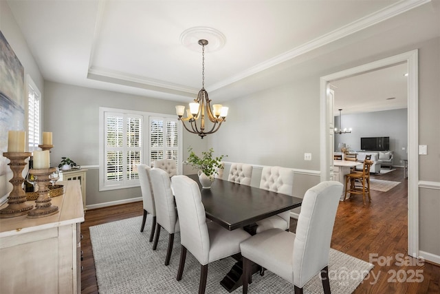 dining space featuring baseboards, a chandelier, a raised ceiling, and dark wood-type flooring