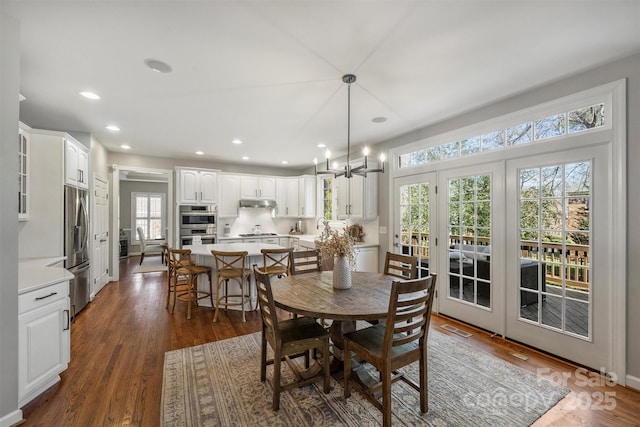 dining space featuring visible vents, a chandelier, dark wood-type flooring, and recessed lighting