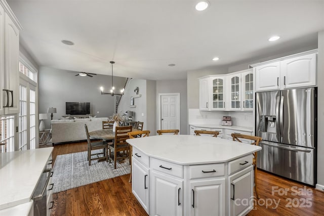 kitchen featuring glass insert cabinets, dark wood-style flooring, stainless steel fridge, and white cabinets