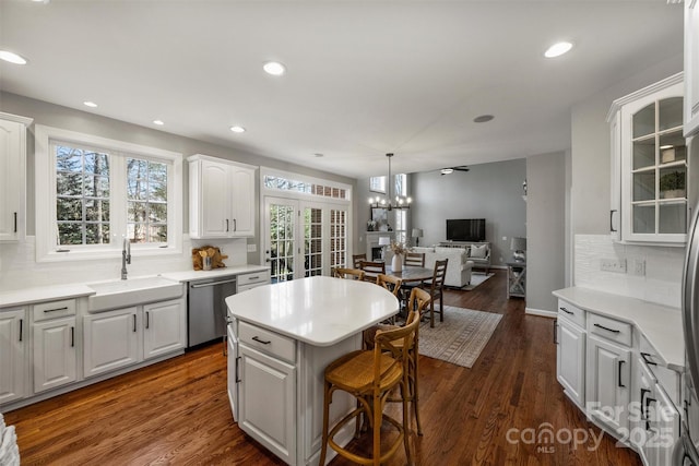 kitchen featuring dark wood-style flooring, a sink, white cabinetry, a center island, and dishwasher