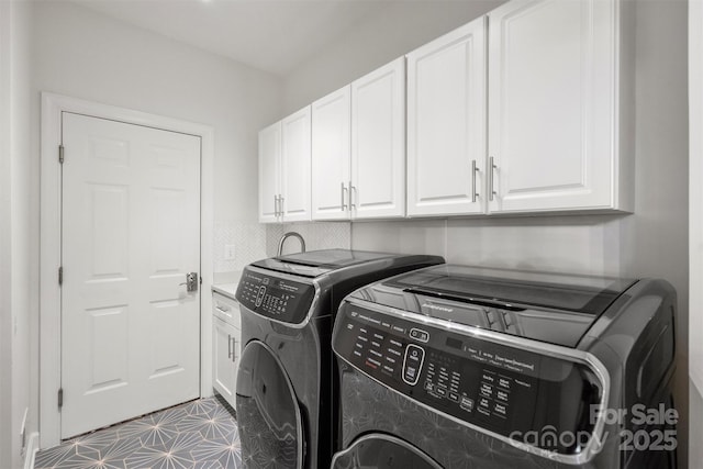 washroom with cabinet space and washer and clothes dryer