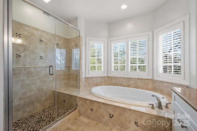 full bath featuring a garden tub, vanity, and a shower stall