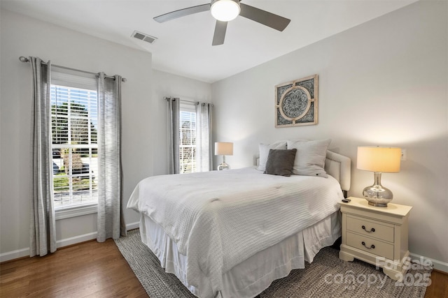 bedroom featuring baseboards, visible vents, ceiling fan, and wood finished floors