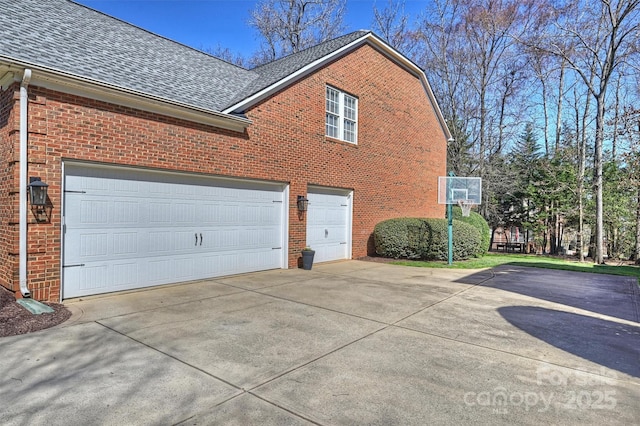 view of property exterior featuring concrete driveway, brick siding, roof with shingles, and an attached garage