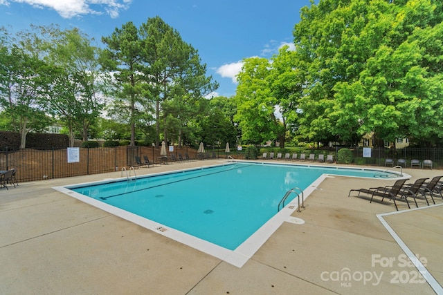 community pool featuring a patio area and fence