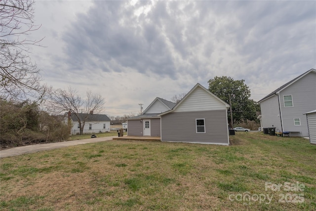 back of property featuring a lawn and a wooden deck